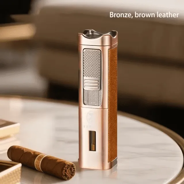 A tall, elegant bronze-finished Rami's Accessories lighter with textured brown leather siding, featuring a fuel window and integrated cigar tools, standing on a marble table next to a premium cigar.