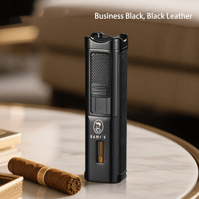 A tall, matte black Rami's Accessories executive lighter with textured black leather siding, featuring a fuel window and the brand logo, standing on a marble table next to a cigar.