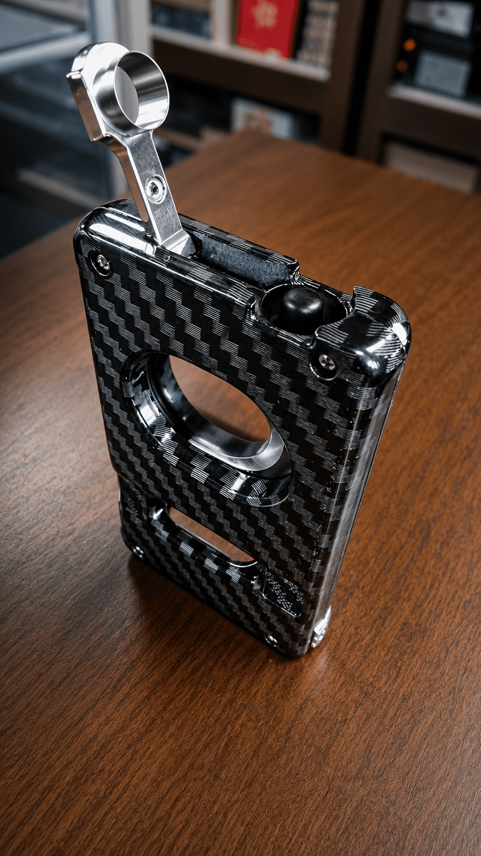 Rami's Carbon Elite Cutter with cigar punch extended, featuring a luxury carbon fiber finish and integrated 4-in-1 cigar tool design.