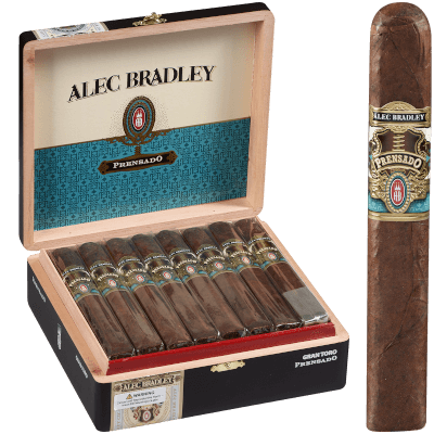 Single Alec Bradley Prensado cigar with dark oily wrapper in front of an open box showing multiple cigars.