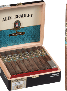 Single Alec Bradley Prensado cigar with dark oily wrapper in front of an open box showing multiple cigars.