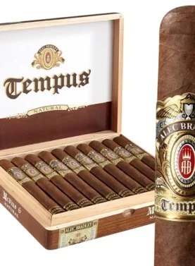 Single Alec Bradley Tempus cigar with dark wrapper, resting in front of an open box showing multiple cigars inside.