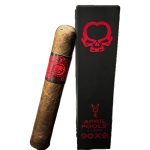 Asylum April Fools cigar resting beside its branded wooden coffin box on a wood surface