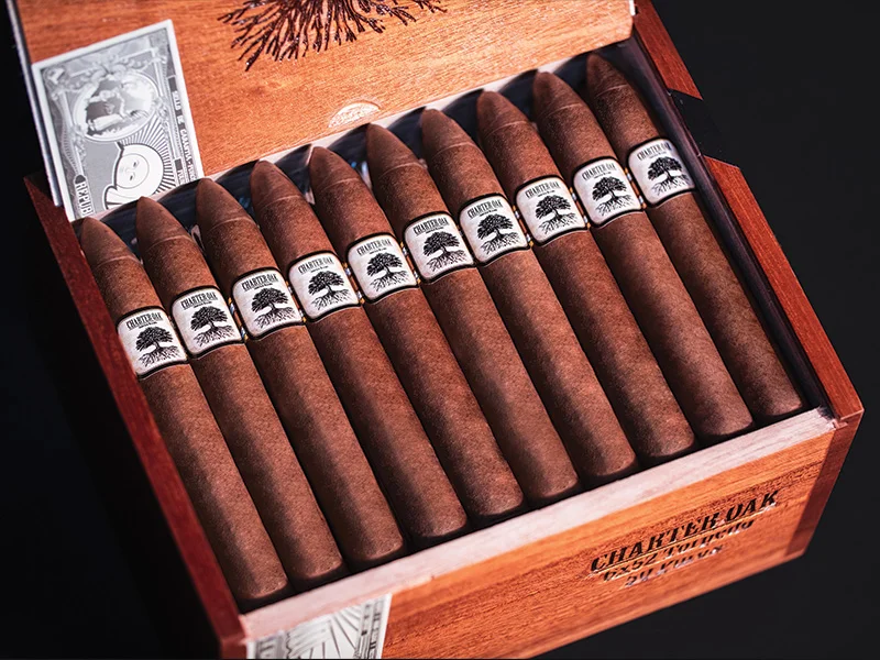 Open box of Charter Oak Habano cigars, featuring rich, golden-brown wrappers neatly arranged in a rustic wooden box