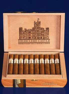 Open box of Highclere Castle cigars, featuring golden-brown wrappers neatly arranged inside an elegant, crest-embossed box