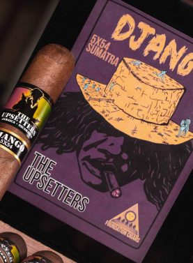 Single The Upsetters cigar resting on a closed box with colorful, vibrant artwork highlighting its unique Jamaican-inspired style