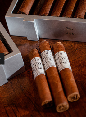 Three Gurkha Cellar Reserve Platinum 12 Year cigars laying on wooden surface