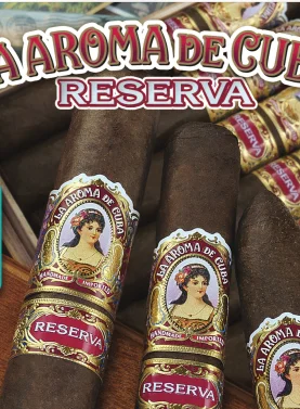 Box of La Aroma de Cuba Reserva cigars with dark, oily wrappers and vintage-style bands neatly arranged in cedar box.