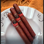 Three La Flor Dominicana Air Bender Double Press cigars resting elegantly on a ceramic dish, showcasing their box-pressed shape and rich brown wrappers.