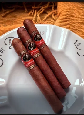 Three La Flor Dominicana Air Bender Double Press cigars resting elegantly on a ceramic dish, showcasing their box-pressed shape and rich brown wrappers.