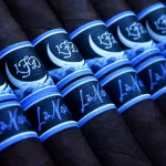 La Flor Dominicana La Nox cigar with a dark, oily wrapper and a striking deep blue and black band featuring a moonlit night design