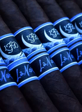 La Flor Dominicana La Nox cigar with a dark, oily wrapper and a striking deep blue and black band featuring a moonlit night design