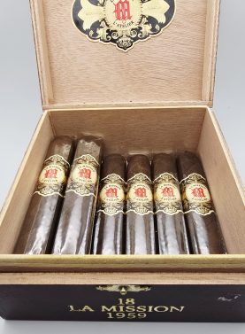 Open box of La Mission du L'Atelier 1959 cigars with dark San Andrés wrappers and elegant red-and-gold bands.