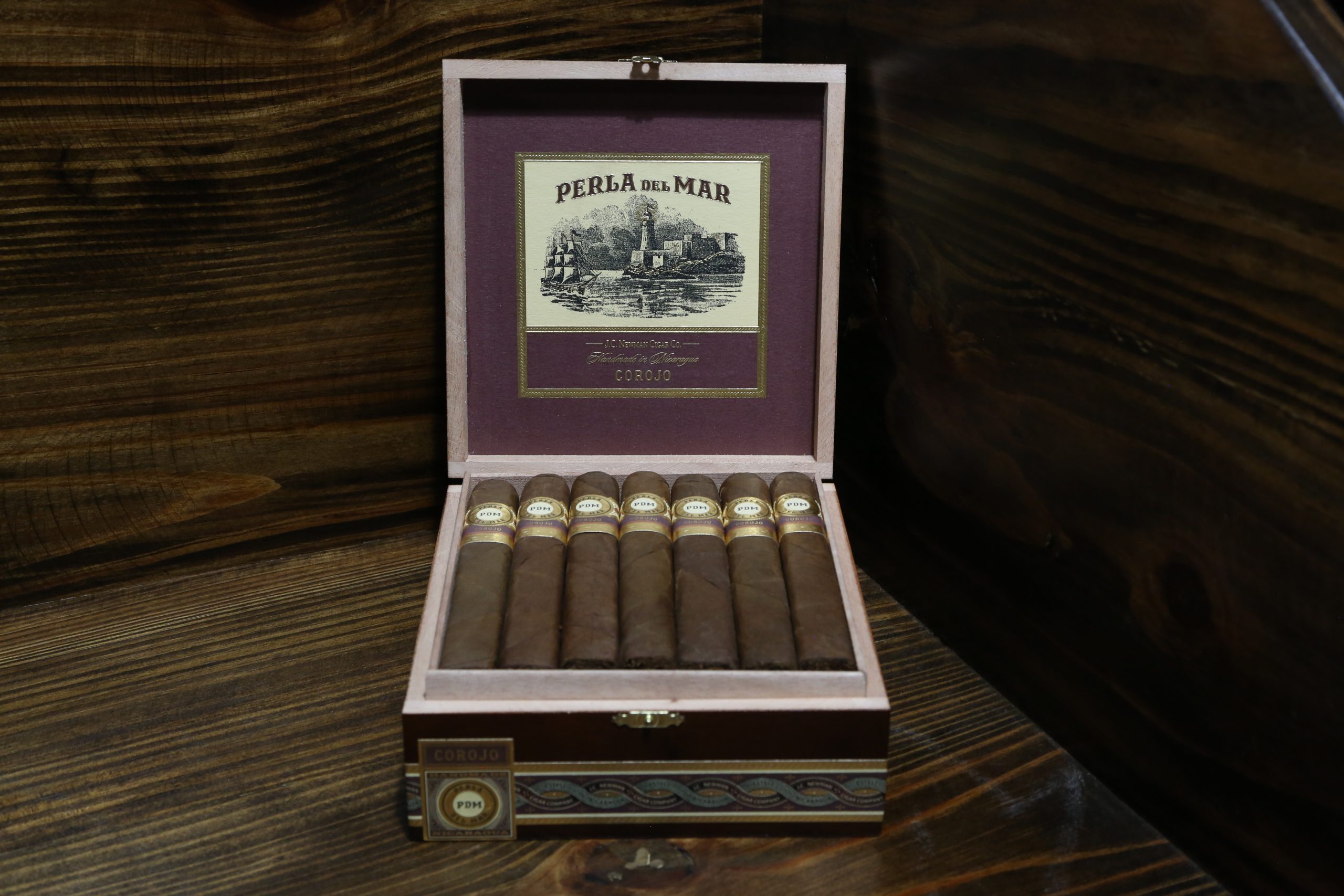 Open box of Perla Del Mar Corojo cigars neatly arranged with reddish-brown wrappers