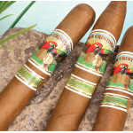 Three San Cristobal Elegancia cigars with light, golden Connecticut wrappers and elegant bands resting beside a clear blue pool on a sunny day."