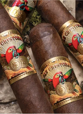 Four San Cristobal Original cigars with dark, rich wrappers and elegant bands arranged in a decorative display, showcasing their premium craftsmanship and refined appeal.