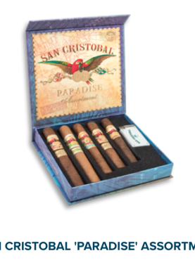 Open box of San Cristobal Paradise Assortment with premium cigars and a branded lighter