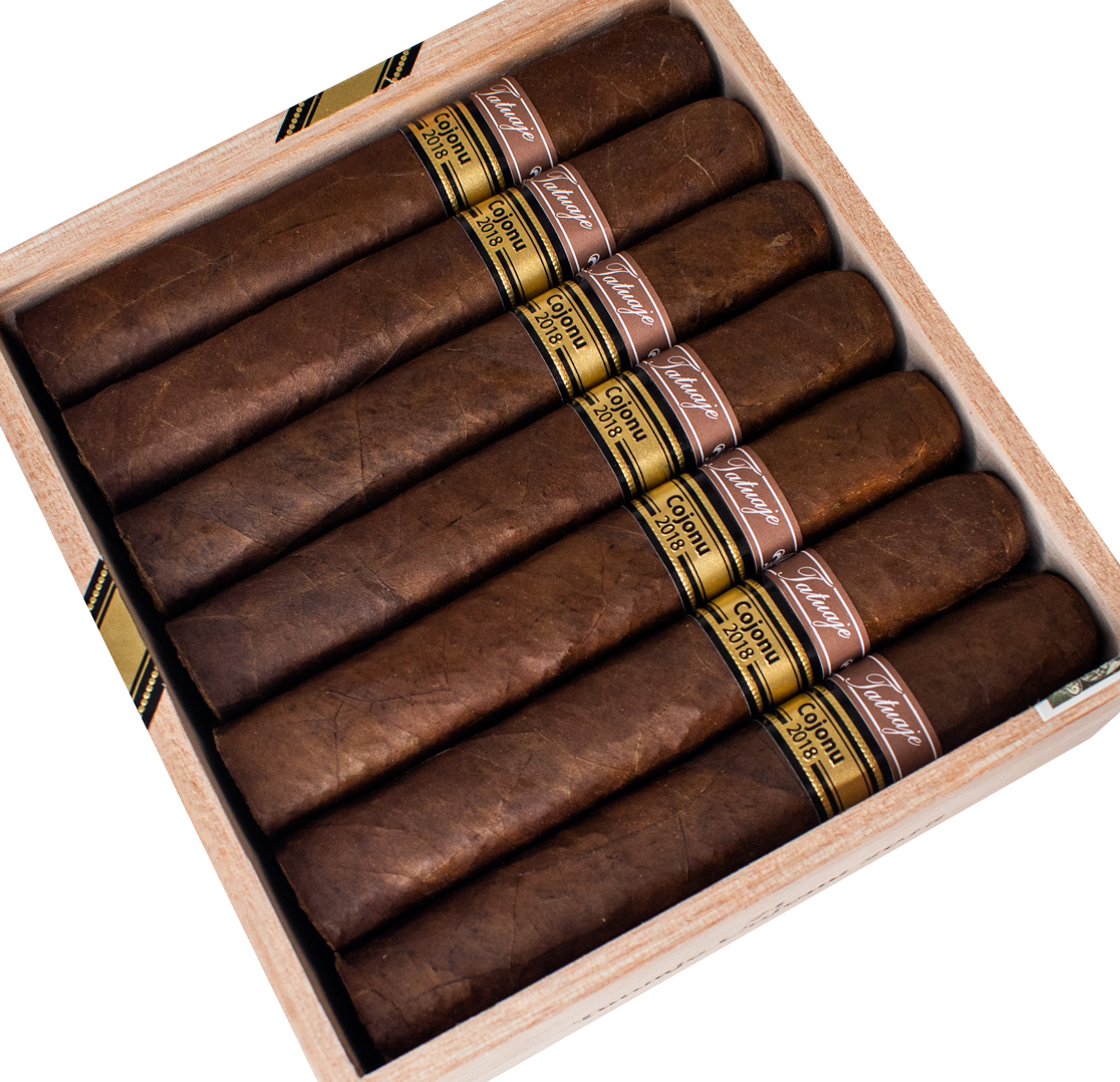 Open box of Tatuaje Cojonu 2018 cigars with rich, dark Ecuadorian Habano wrappers and bold, vintage-inspired branding.