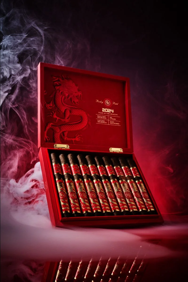 Open box of Rocky Patel Year of the Dragon cigars with elegantly arranged cigars and vibrant packaging.