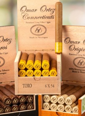 Three open boxes of Omar Ortez cigars showing Connecticut and Maduro wrappers, neatly arranged with visible cigar bands.