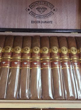 Open box of Montecristo 1935 Anniversary Edición Diamante Grande cigars with luxurious Nicaraguan wrappers and gold-accented presentation.