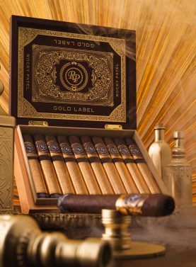 Open box of Rocky Patel Gold Label cigars, showcasing perfectly arranged cigars with elegant, gold-accented packaging.