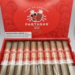 Open box of Partagás Cortado cigars with smooth, light-colored wrappers and gold-accented bands.