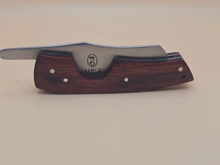 Rami's cigar knife with red wood handle and stainless steel blade displayed on a neutral background
