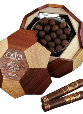 The file oliva-seriev-soccer-ball-melanio.jpg displays an open, soccer-ball-shaped wooden humidor box filled with round premium cigars, showcasing the Oliva Serie V Melanio Gran Reserva Limitada Double Toro Soccer Edition logo on the removable multi-toned wood lid alongside two cigars with specialized foot bands featuring a soccer ball icon.