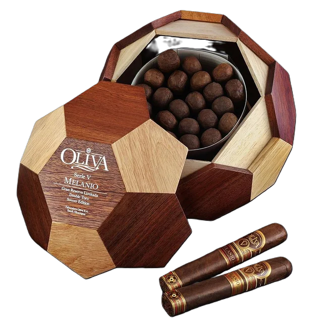 The file oliva-seriev-soccer-ball-melanio.jpg displays an open, soccer-ball-shaped wooden humidor box filled with round premium cigars, showcasing the Oliva Serie V Melanio Gran Reserva Limitada Double Toro Soccer Edition logo on the removable multi-toned wood lid alongside two cigars with specialized foot bands featuring a soccer ball icon.