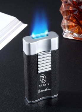 A textured black and silver Rami's Bondu cigar lighter emitting a wide, flat blue waterfall-style torch flame, positioned next to a glass of bourbon.