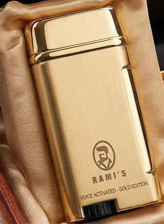 A premium brushed gold Rami's Accessories lighter nestled in a gold satin-lined gift box, featuring the official brand logo and "VOICE ACTIVATED - GOLD EDITION" engraving.