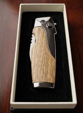 Rami's Vanguard cigar lighter with a natural oak wood finish and polished chrome hardware, featuring an integrated folding cigar knife with a locking mechanism, in a presentation box.