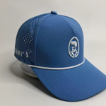 A studio product shot of a cobalt blue Rami's Apex Performance Cap, featuring a white rope trim on the brim, laser-perforated side panels for breathability, and the signature "Rami's" brand logo embroidered in white on the front.